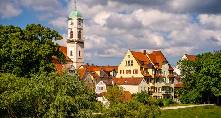 Charmante Stadt mit Kirchturm inmitten üppigen Grüns.