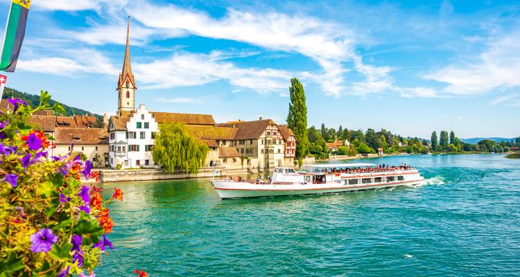 Un navire de croisière sur une rivière près d'une charmante ville européenne.