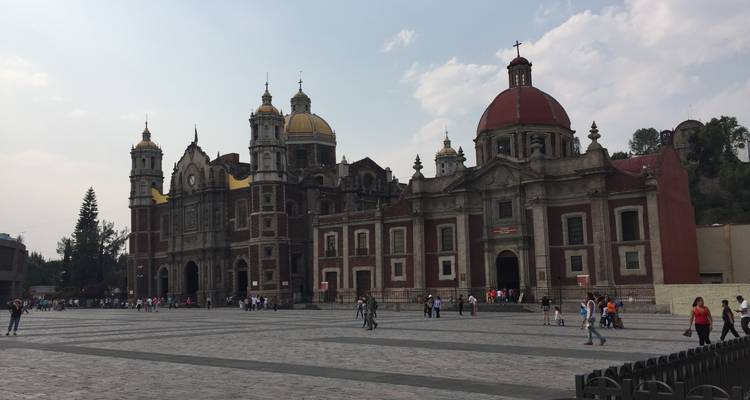Historische Kirche mit einem Platz, Menschen gehen umher.