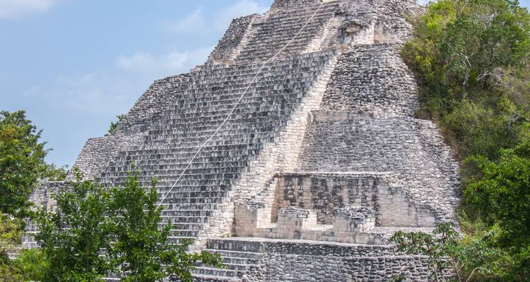 Große Steinpyramide eingebettet in Grün, von der Seite fotografiert.