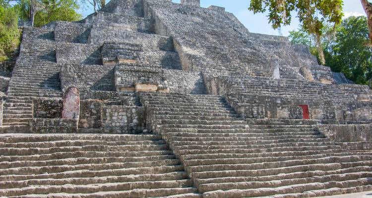 Alte Steinstufen und Bauwerke mit umgebender Vegetation.