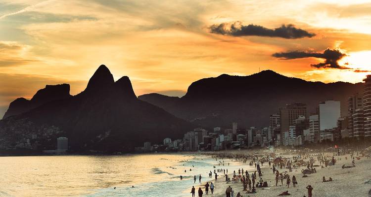 Popular beach in Rio de Janeiro with people enjoying the sunset.