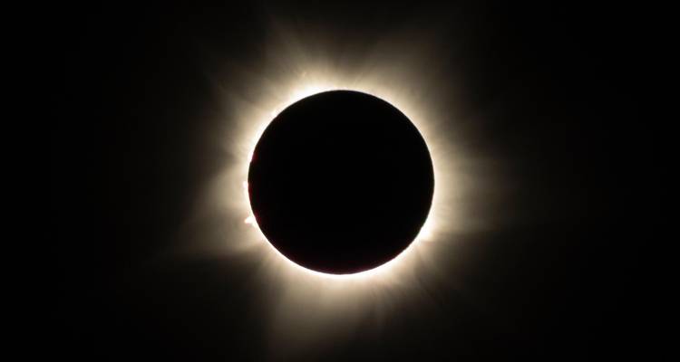 Solar eclipse with a black circle surrounded by a glowing ring.