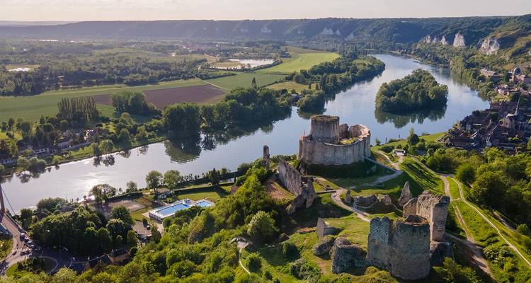 Vue aérienne de la Seine serpentant devant les ruines médiévales du Château Gaillard entourées d'une campagne luxuriante.