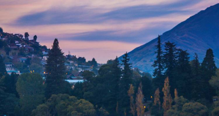 A hilly residential area under colorful dusk skies.