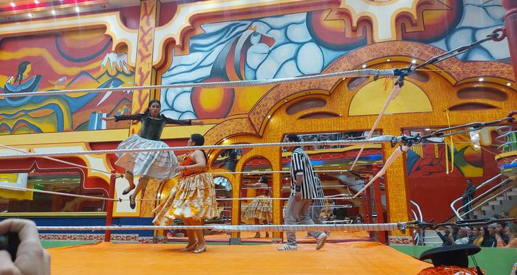 Wrestling match with costumed wrestlers in a colorful arena.