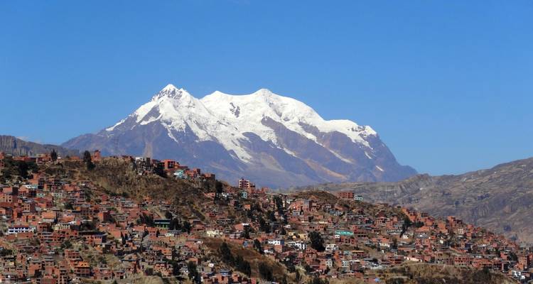 Panoramic view of a city with a snow-capped mountain in the background.