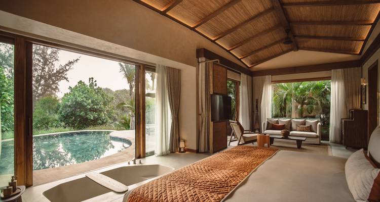 Intérieur élégant d'une chambre d'hôtel avec vue sur la piscine et mobilier luxueux.