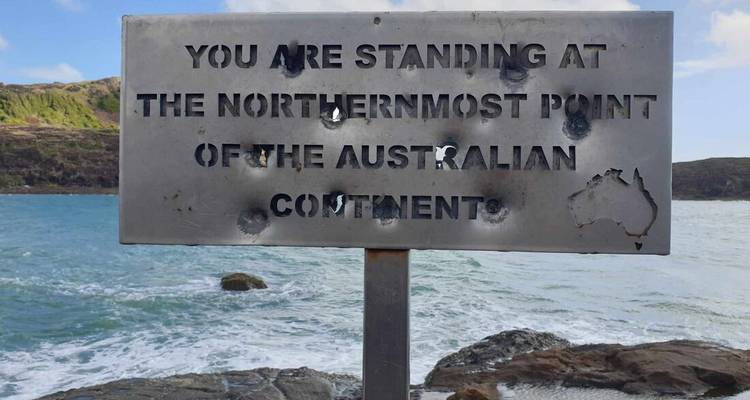 Panneau indiquant le point le plus au nord du continent australien avec l'océan en arrière-plan.