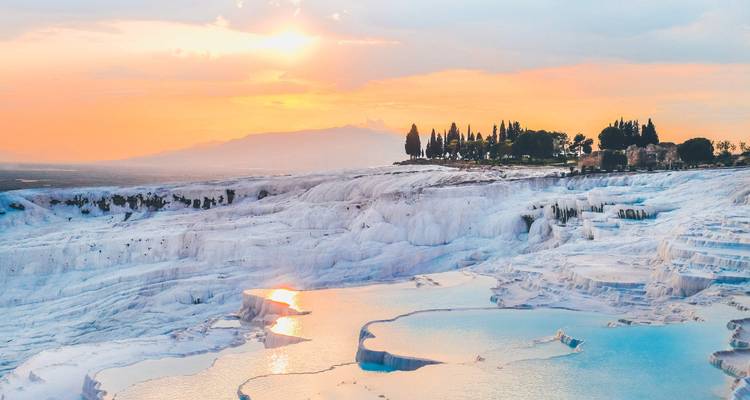 Sunset view of the white terraces with a colorful sky and reflection.