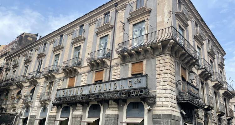 Historic building with detailed balconies and signs.
