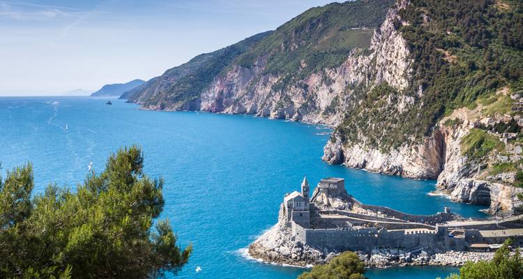 Die Kirche San Pietro liegt dramatisch auf einer felsigen Landzunge, die in die leuchtend türkisfarbenen ligurischen Gewässer hineinragt.