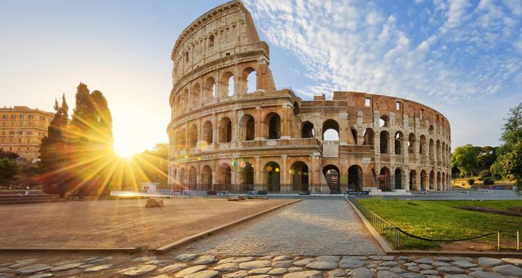 Iconic view of the Colosseum with the sun shining through.