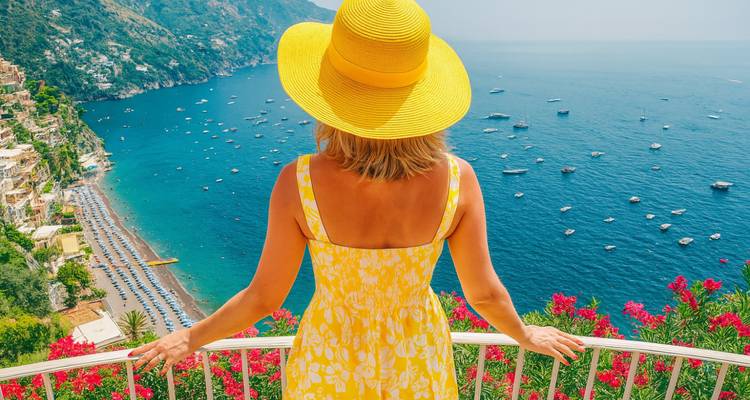 Vrouw in gele jurk met uitzicht op de Amalfikust.