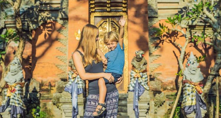 Woman and child in front of traditional Balinese temple.