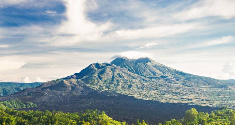 Majestic mountain landscape with clear skies and distant volcano.