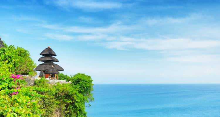 Temple perched on a cliff overlooking the ocean.