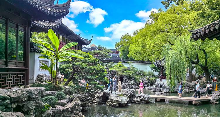 Traditional garden with a pond and walking tourists.