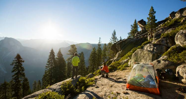 Campistas disfrutando de una vista del amanecer sobre un valle.