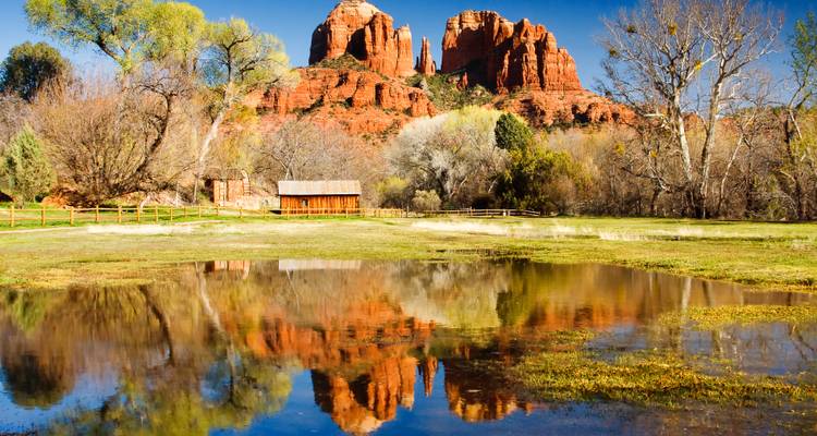 Reflejos de formaciones rocosas rojas en un estanque.