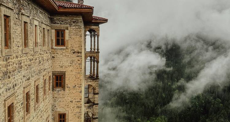 Monastery building with misty forest in the background.