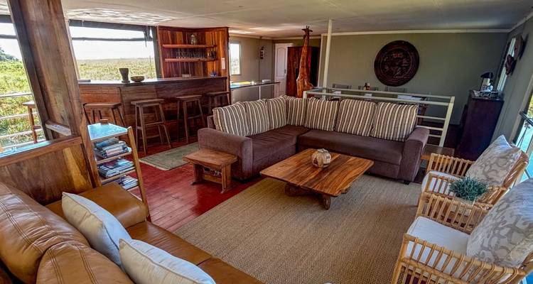 Cozy indoor living area with couches and bar on a houseboat.