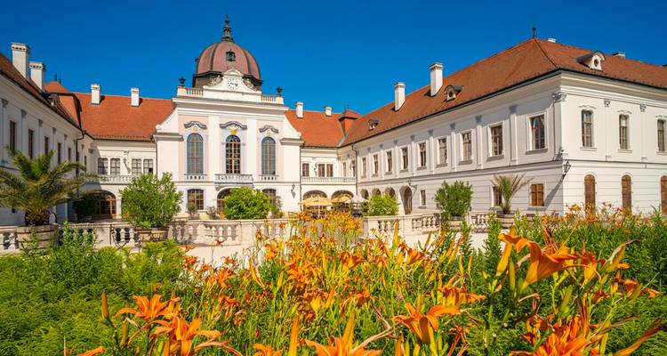 Ein großartiger Palast umgeben von einem lebendigen Garten mit Blumen.