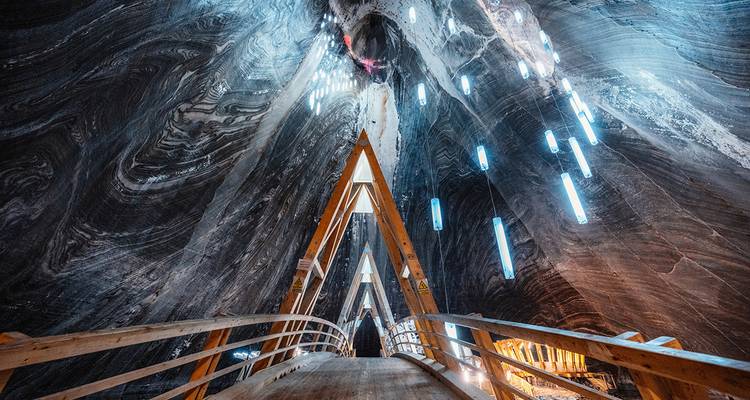 In einem großen höhlenartigen Raum mit Beleuchtung und einem Holzweg.