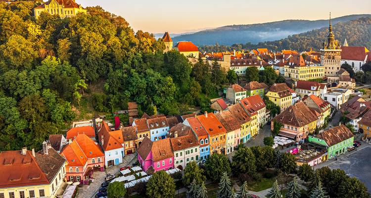 Eine malerische Stadt umgeben von üppigem Grün und bunten Häusern.
