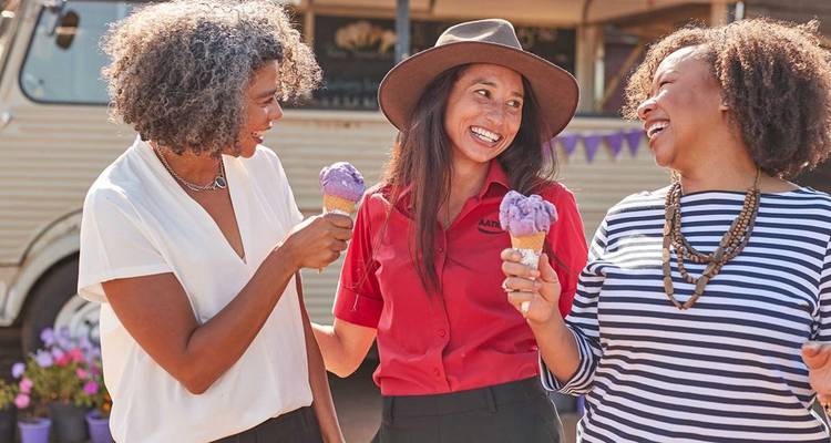 Trois femmes savourant une glace en plein air.
