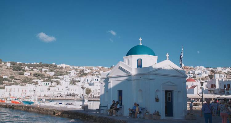 White and blue domed church by the sea in Mykonos, Greece.