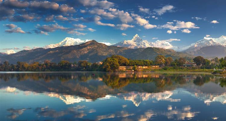 Schneebekleidete Himalaya-Gipfel spiegelten sich perfekt in einem ruhigen See unter klarem Himmel.