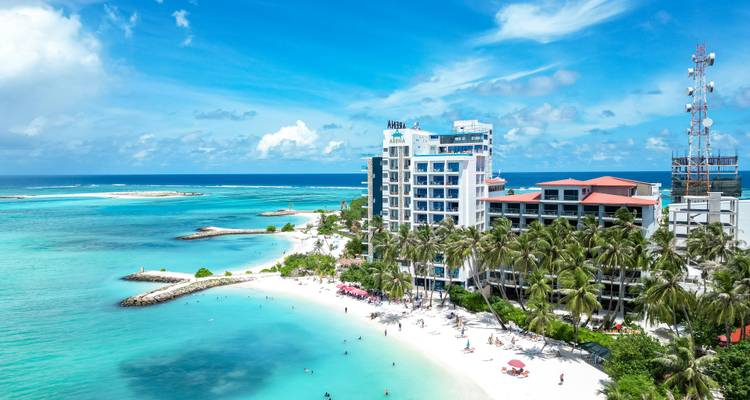 Vue aérienne d'une ville côtière avec hôtels et plages.