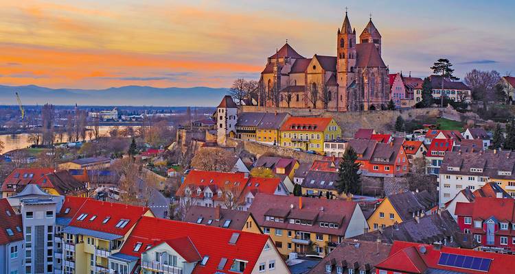 Picturesque sunset view of a historic town in Germany with a church and colorful houses.