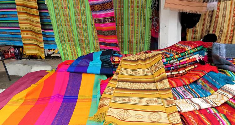 Tissus tissés colorés exposés dans un marché.