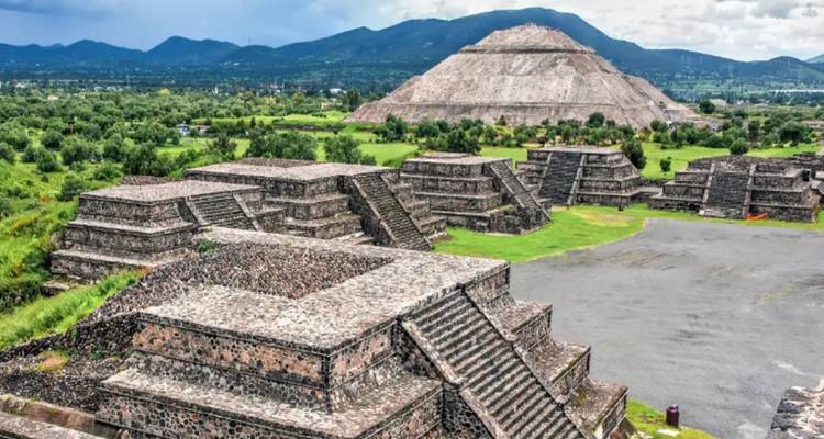 Antike Pyramidenstrukturen in einer grünen Landschaft.