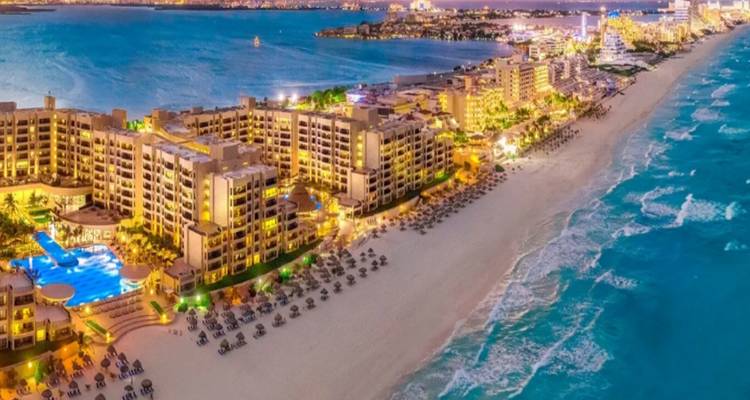 Luftaufnahme eines Strandresorts mit türkisfarbenem Wasser.