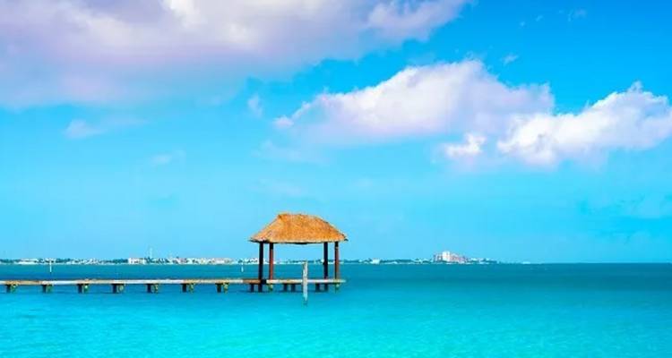 Steg mit einem Pavillon über klarem blauem Wasser.