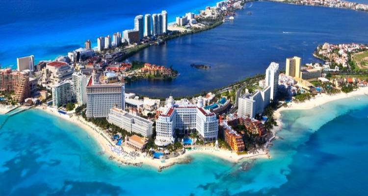 Luftaufnahme einer Küstenstadt, umgeben von blauem Meerwasser.