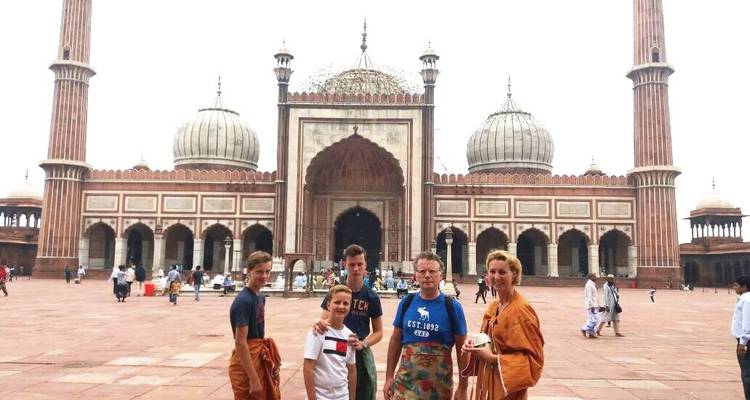 A group of people standing outside a mosque.