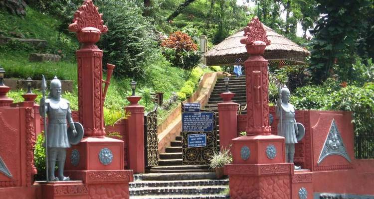 Entrance to a garden with statues and decorative elements.