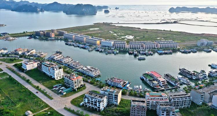 Vue aérienne d'un port et des bâtiments environnants avec des îles calcaires.