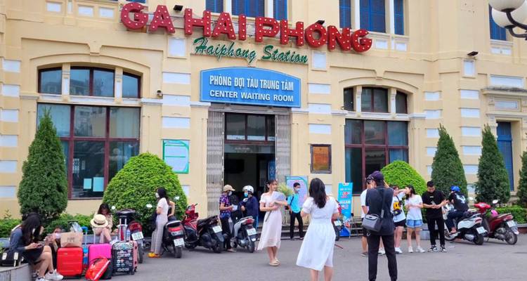Des gens attendent à l'extérieur de la gare de Ga Hai Phong.