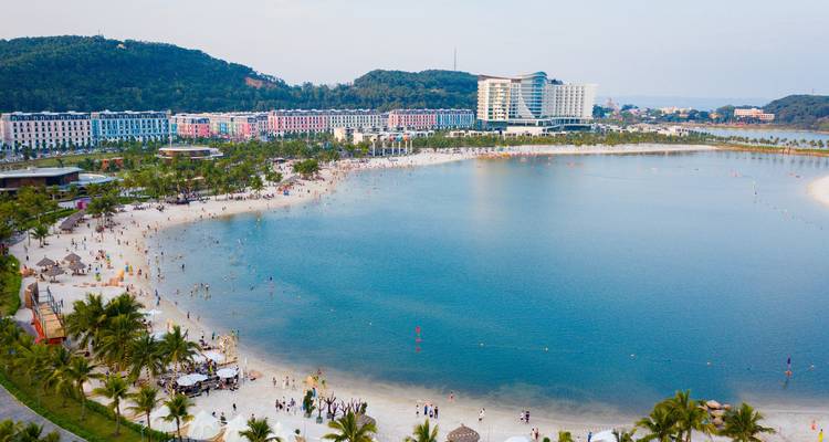 Vue aérienne d'une zone de plage avec des hôtels et des centres de villégiature.
