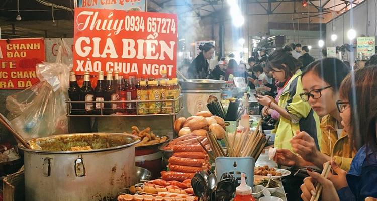 Scène de marché de cuisine de rue avec des gens et des stands de nourriture.