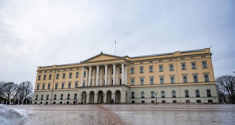 Bâtiment du Palais Royal sur une place ouverte enneigée.