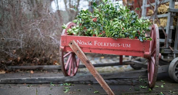Chariot rouge décoré de feuilles de houx et de baies.