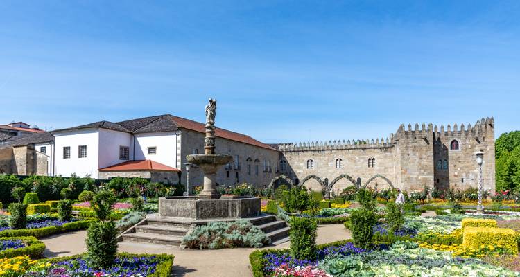 Historic building with a garden full of vibrant flowers.