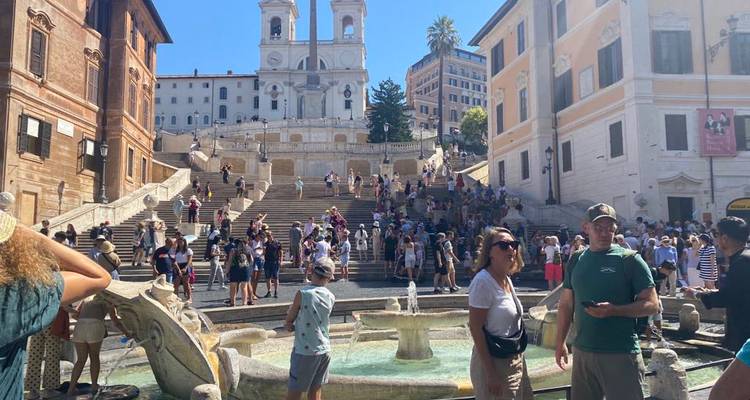 Crowded plaza with a large staircase and buildings.