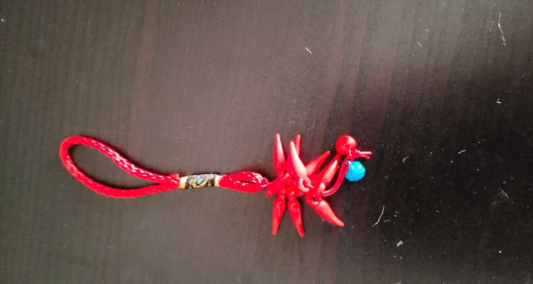Un objet décoratif rouge sur une surface sombre.